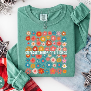 a green long-sleeved shirt with a colorful floral design, a pair of jeans, and some decorative star-shaped embellishments.