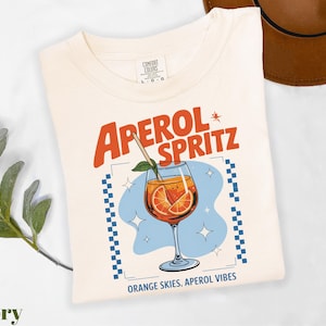a t - shirt with a picture of an orange drink on it
