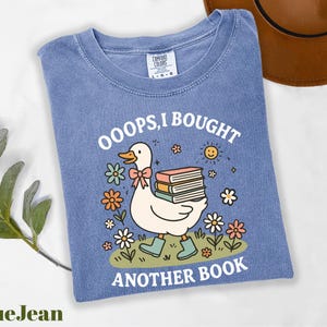 a blue shirt with a duck reading a book
