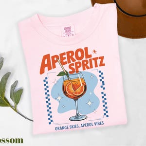 a pink shirt with an orange slice on it