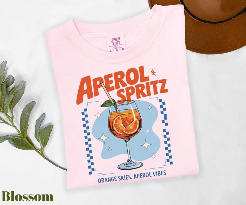 a pink shirt with an orange slice on it