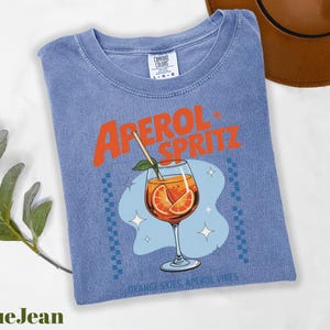 a blue shirt with an orange drink in it