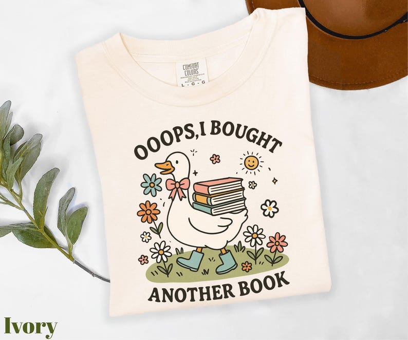 a white shirt with a duck holding a stack of books