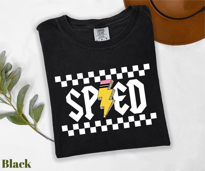 A black t-shirt with a checkered pattern and the word "SPEED" printed on it, along with a brown hat and a green plant.