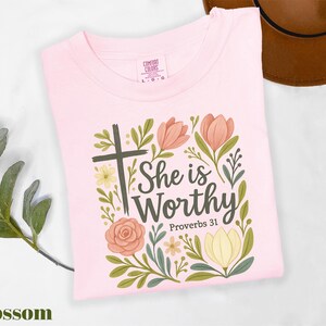 a pink shirt with a cross and flowers on it