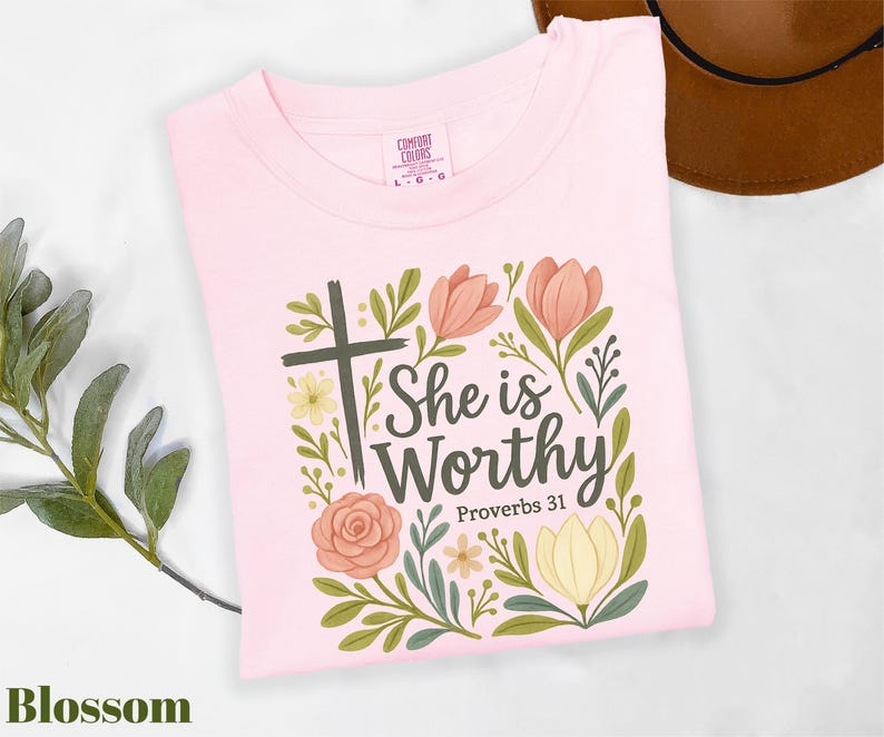 a pink shirt with a cross and flowers on it