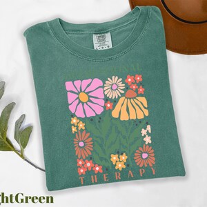 a green t - shirt with a picture of flowers on it