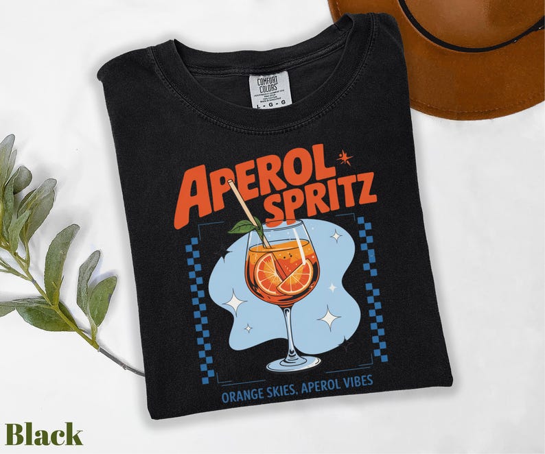 a black t - shirt with an orange drink on it