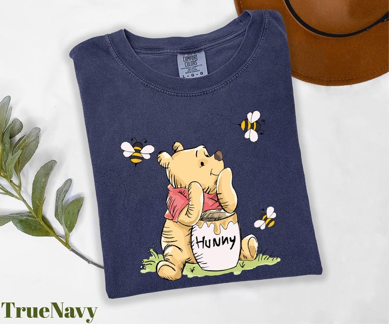 a t - shirt with a picture of a winnie the pooh holding a honey