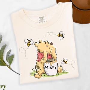 a winnie the pooh t - shirt sitting on top of a table