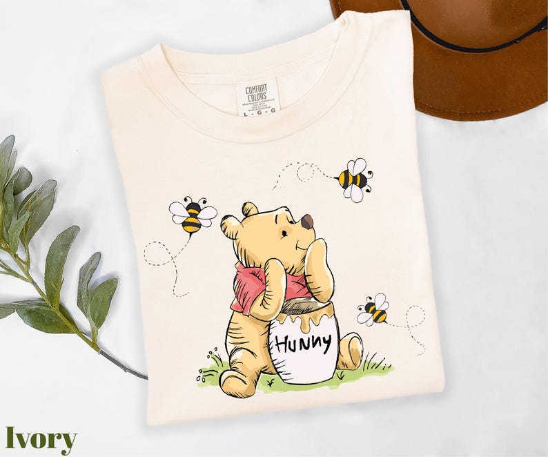 a winnie the pooh t - shirt sitting on top of a table