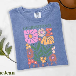 a blue t - shirt with a picture of flowers on it