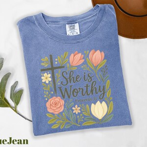 a t - shirt with a cross and flowers on it