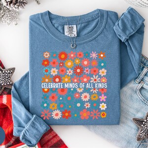 a blue long-sleeved shirt with a floral design, a pair of jeans, and some decorative star-shaped embellishments.