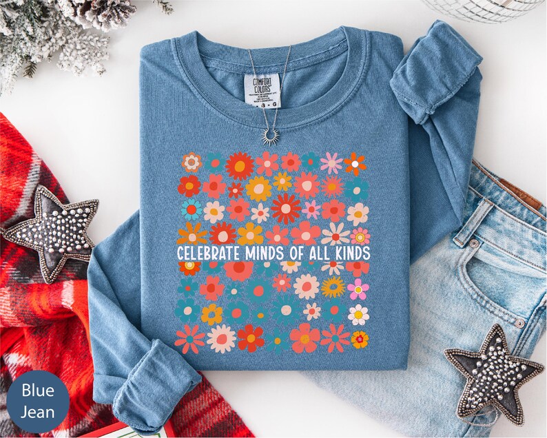 a blue long-sleeved shirt with a floral design, a pair of jeans, and some decorative star-shaped embellishments.