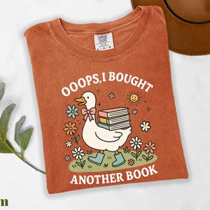 a t - shirt with a picture of a duck reading a book
