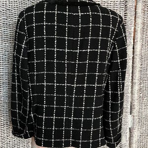 K&ouml;nnte beinhalten: Schwarz-wei&szlig; kariertes Blazer mit Kragen. Der Blazer ist aus einem tweedartigen Stoff.