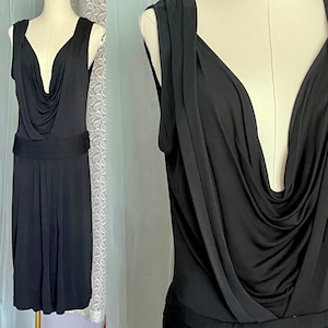 May include: A black sleeveless dress with a cowl neck and a fitted bodice. The dress has a gathered skirt and a fitted waist.