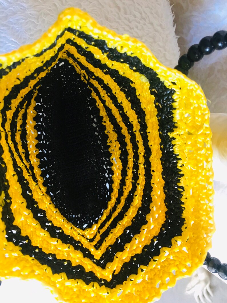 May include: A black and yellow crocheted bag with a black beaded handle.