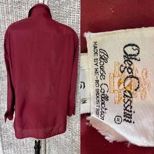 以下が含まれることがあります： 白地に「Olde's Classix Blouse Collection Made by He-Ro Industries」と書いてあるラベルが付いた、ワインレッドのロングスリーブボタンダウンシャツです。