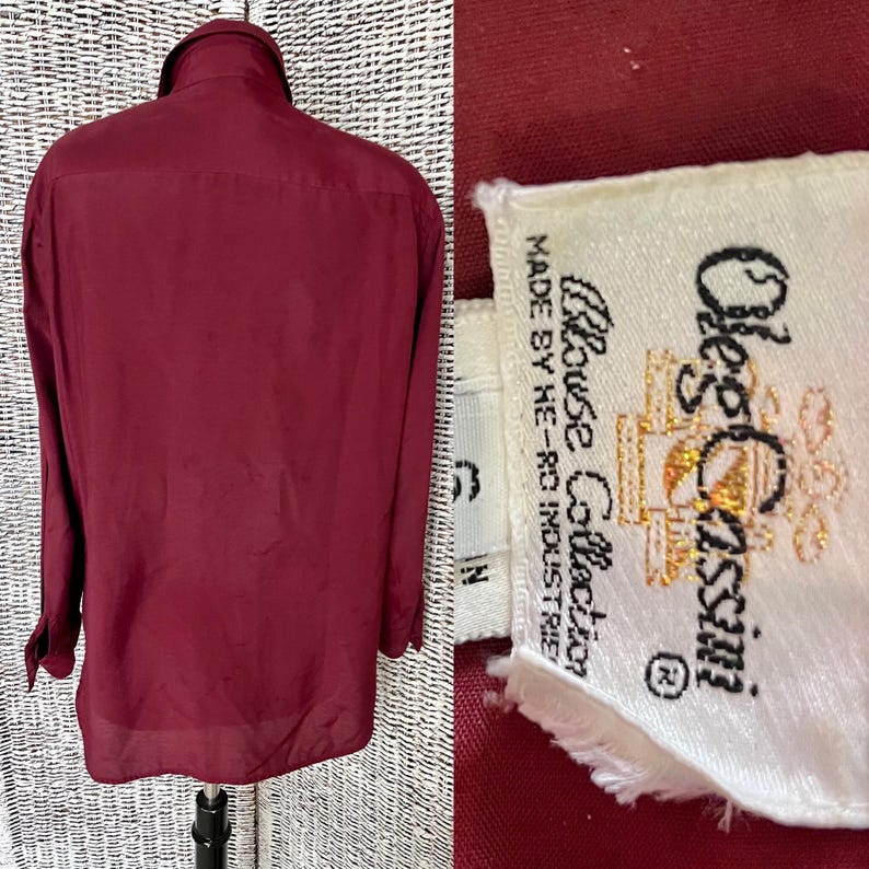以下が含まれることがあります： 白地に「Olde's Classix Blouse Collection Made by He-Ro Industries」と書いてあるラベルが付いた、ワインレッドのロングスリーブボタンダウンシャツです。