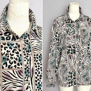 Pode incluir: Camisa abotoada com design de patchwork com listras de zebra, manchas de leopardo e padrões geométricos em preto, branco, verde-azulado e roxo. A camisa tem gola e mangas compridas.