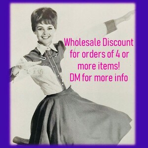 May include: A black and white photo of a woman wearing a white shirt with a western-style design and a black skirt. The text "Wholesale Discount for orders of 4 or more items! DM for more info" is written in pink on the image.