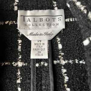 K&ouml;nnte beinhalten: Schwarze und wei&szlig;e Tweedjacke mit einem Etikett mit der Aufschrift "Talbots Collection Made in Italy" und einem Gr&ouml;&szlig;enetikett mit der Aufschrift "14 Made in Italy Fabrique en Italie".