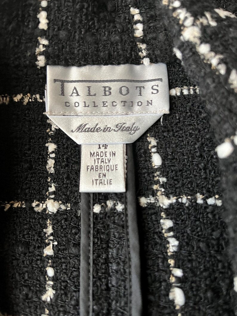 K&ouml;nnte beinhalten: Schwarze und wei&szlig;e Tweedjacke mit einem Etikett mit der Aufschrift "Talbots Collection Made in Italy" und einem Gr&ouml;&szlig;enetikett mit der Aufschrift "14 Made in Italy Fabrique en Italie".