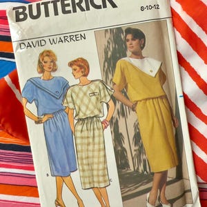 May include: A vintage sewing pattern from Butterick, designed by David Warren. The pattern is for a dress with a collar and is available in sizes 8-10-12. The pattern features a line drawing of a woman wearing the dress.