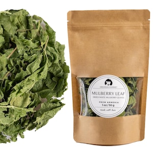 Könnte beinhalten: Braune Papiertüte mit getrockneten weißen Maulbeerblättern. Das Etikett zeigt "MULBERRY LEAF" und "FROM ARMENIA". Links ein Haufen getrockneter Blätter. Die Tüte enthält 30g Produkt.