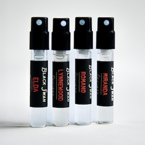 May include: Four perfume sample vials with black caps and labels. The labels read "ELDA", "LYNNEWOOD", "ROMANO", and "MIRANDA" in white and red text. The brand name "Black Swan Society" is also printed on the labels.