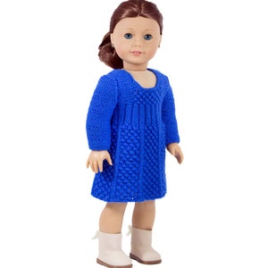 May include: A blue knitted dress for a doll. The dress has a textured pattern and a scoop neckline.