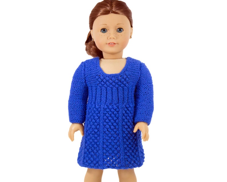 May include: A blue knitted dress with a textured pattern. The dress has long sleeves and a scoop neckline.