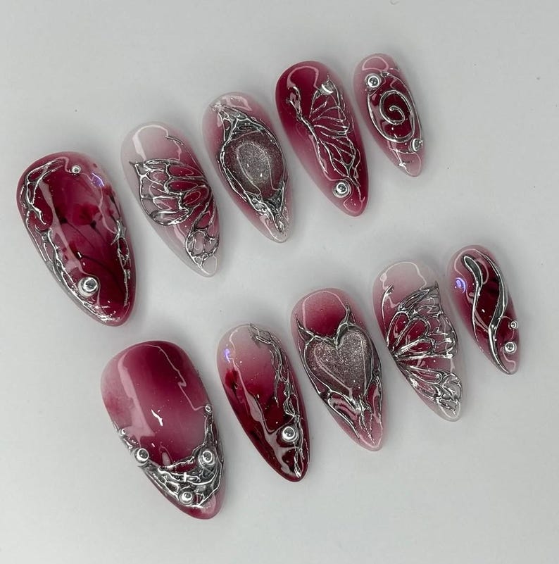 Uñas postizas 3D en cromo rojo, diseño de corazón metálico color vino, uñas con alambre plateado Y2K, uñas postizas en color vino tinto para ocasiones especiales, uñas cromadas imagen 3