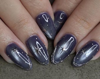 May include: Close-up of a set of manicured nails. The nails are oval-shaped and painted a dark purple color with silver accents. Each nail features a silver star design and a silver border.