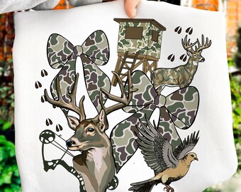 May include: White graphic featuring a deer head with a bow and arrow, a deer, a dove, a hunting blind, and camouflage bows. The design incorporates brown, green, and white elements, with deer tracks scattered throughout.