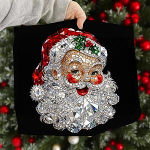 May include: A black square pillow featuring a mosaic-style Santa Claus design. The Santa Claus has a red hat, rosy cheeks, and a white beard, all made of sparkling, reflective materials. A sprig of green holly with red berries is on the hat.