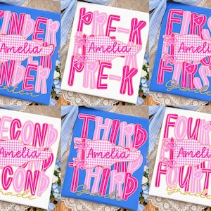 May include: A collection of six t-shirts featuring pink and white text designs. Each shirt displays a grade level from Kinder to Fourth Grade, a pink gingham pennant with the name Amelia in cursive, and a blue or white fabric background.