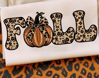 May include: A cream-coloured fabric featuring the word "FALL" in large, stylised letters. The letter shapes are filled with a leopard print pattern. An orange pumpkin with a leopard print bow is in the centre. The background has an orange and black leopard print.