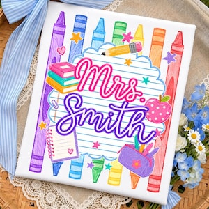 May include: A rectangular white canvas featuring a colorful school-themed illustration with vertical crayons, a stack of books, a pencil, a notebook, a pencil case, and a polka-dot apple. The text Mrs. Smith is written in purple script.