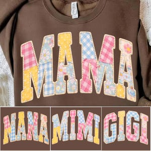 Puede incluir: Una sudadera marrón con la palabra "MAMA" aplicada en el pecho con un diseño de patchwork. Las letras están hechas de varias telas florales y de cuadros en rosa, azul y amarillo. Debajo están las palabras "NANA", "MIMI" y "GIGI".