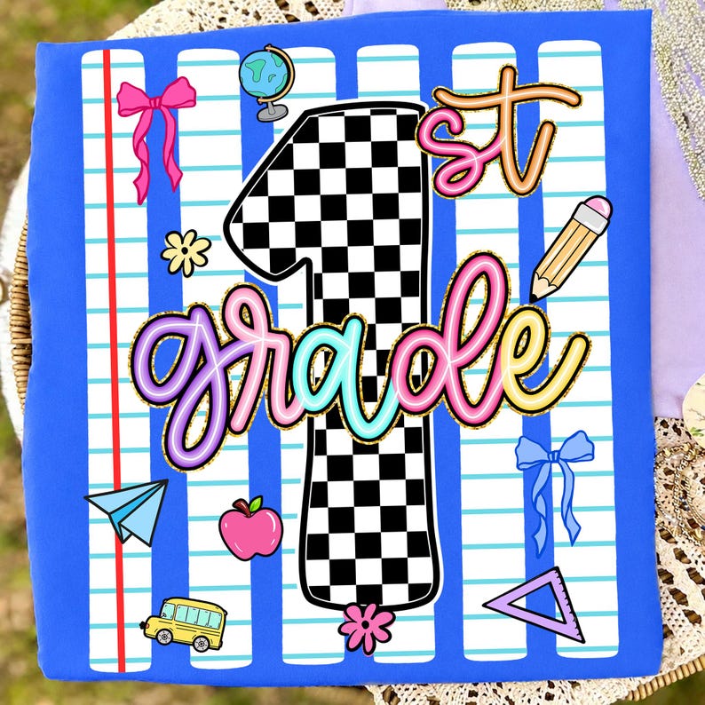 May include: A blue t-shirt featuring a graphic print of a large black and white checkered number one, the text 1st grade in colorful script, and school-themed icons including a globe, pencil, apple, school bus, paper plane, and bows.