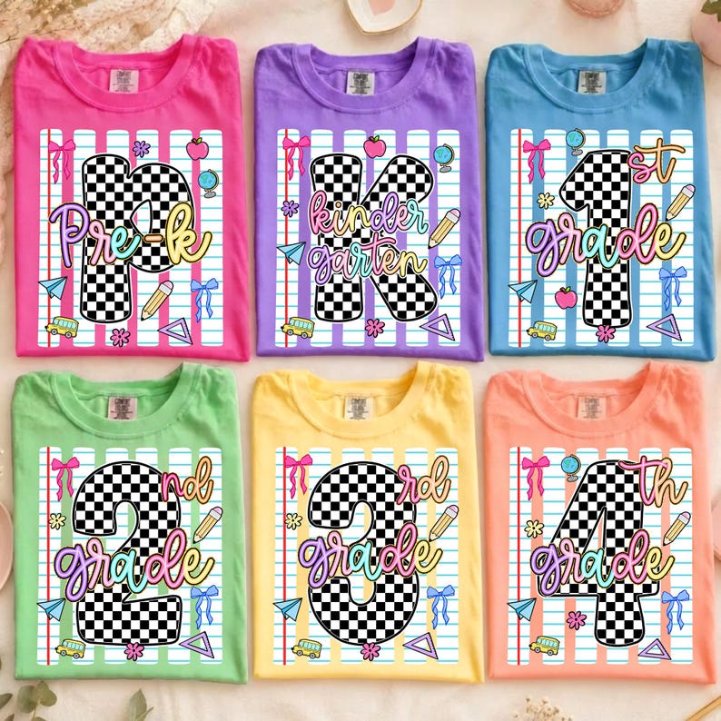 May include: Six t-shirts in pink, purple, blue, green, yellow, and orange, each featuring a graphic of a large checkered number or letter, the text Pre-k, Kindergarten, 1st, 2nd, 3rd, or 4th grade, and school-themed icons like pencils and buses.