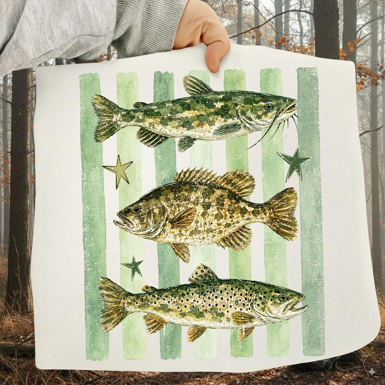 May include: A white rectangular decorative pillow featuring three detailed illustrations of fish in shades of green and brown. The fish are set against a background of vertical green stripes and accented with green star shapes.