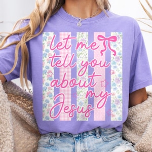 K&ouml;nnte beinhalten: Ein lilafarbenes T-Shirt mit dem rosa Schriftzug "Let me tell you about my Jesus". Der Text ist vor vertikalen Streifen mit Blumen- und Vichy-Mustern platziert.