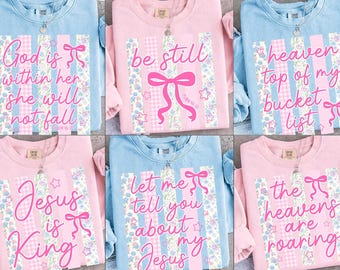 Könnte beinhalten: Eine Auswahl an pastellfarbenen Sweatshirts mit inspirierenden Zitaten. Jedes Shirt hat ein einzigartiges Design mit Text, Bändern und floralen Mustern. Die Zitate beinhalten Sätze wie "Gott ist in ihr" und "Jesus ist König."