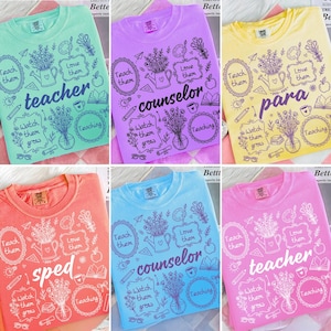 May include: A collection of colorful t-shirts, each featuring a unique design with the words "teacher", "counselor", "para", and "sped". The shirts have a floral and school-themed graphic.