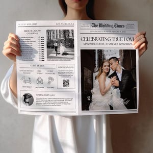 Op de afbeelding: Een huwelijksaankondiging in krantenstijl, getiteld "The Wedding Times", vastgehouden door een persoon. De aankondiging bevat foto's van het paar en de tekst "CELEBRATING TRUE LOVE".