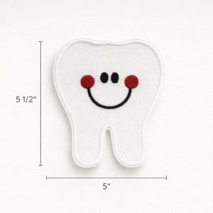 May include: White embroidered tooth patch with a smiling face, featuring red cheeks and a black smile. The patch measures 12.7 cm wide and 14 cm tall. A fun, whimsical design for dental-themed crafts or apparel.